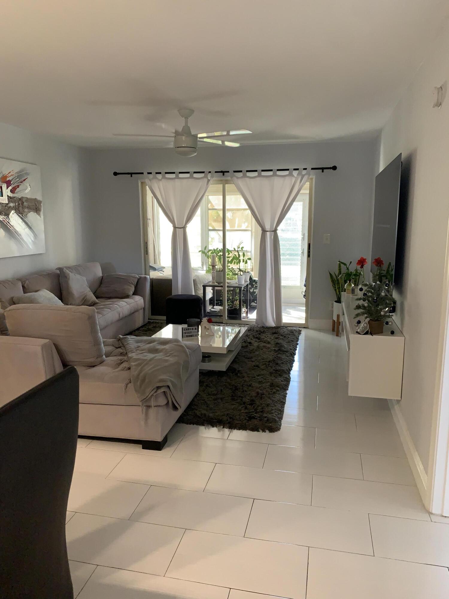 2500 Fiore Way, Unit 109 Delray Beach, FL 33445 - Photo 4 of 16 a living room with furniture and a large window