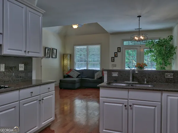 a kitchen with kitchen island granite countertop a sink cabinets and window