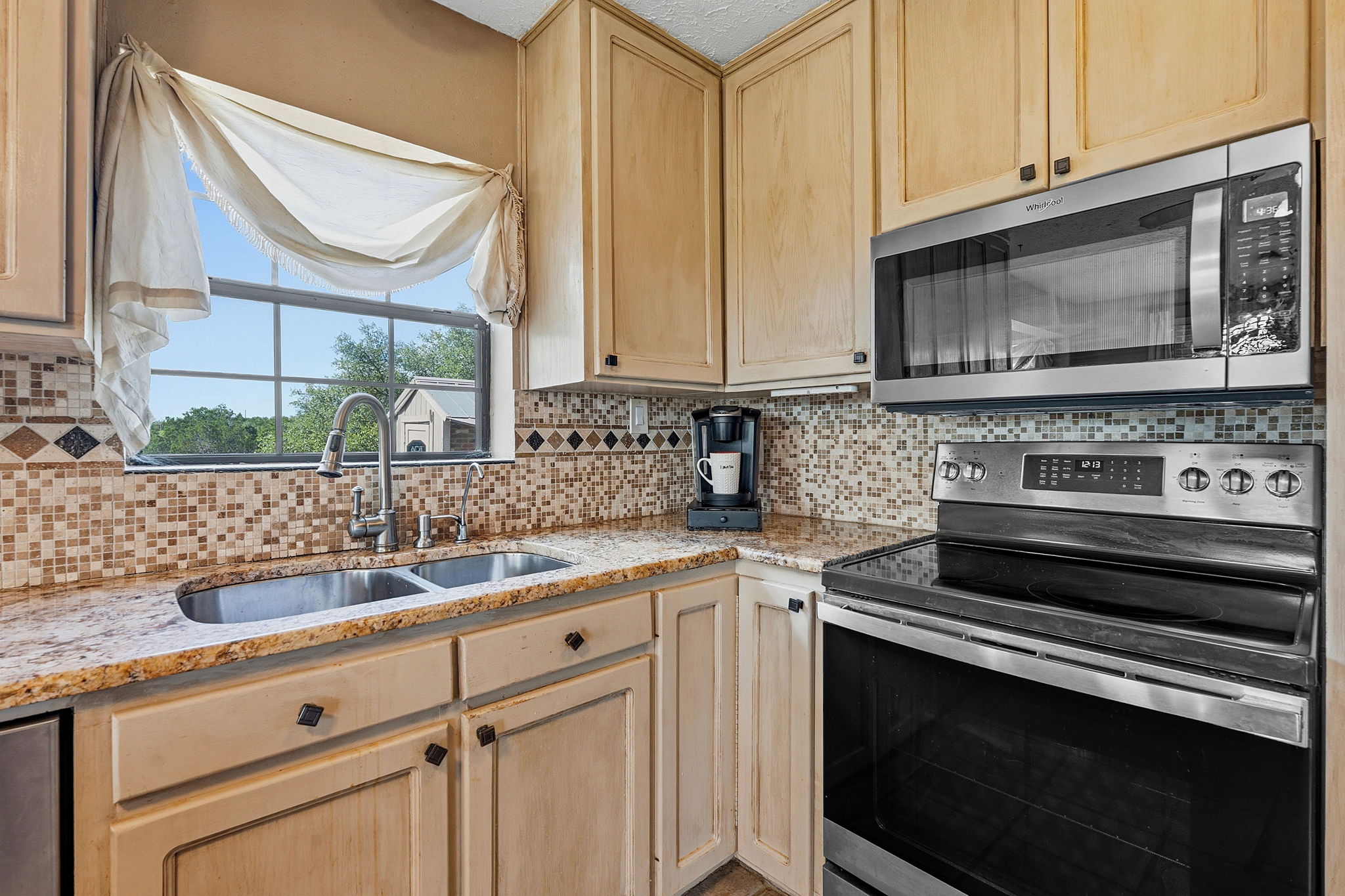 3230 West Fitzhugh Road Dripping Springs, TX 78620 - Photo 13 of 34 A well-appointed kitchen features a double basin sink and stainless steel appliances.