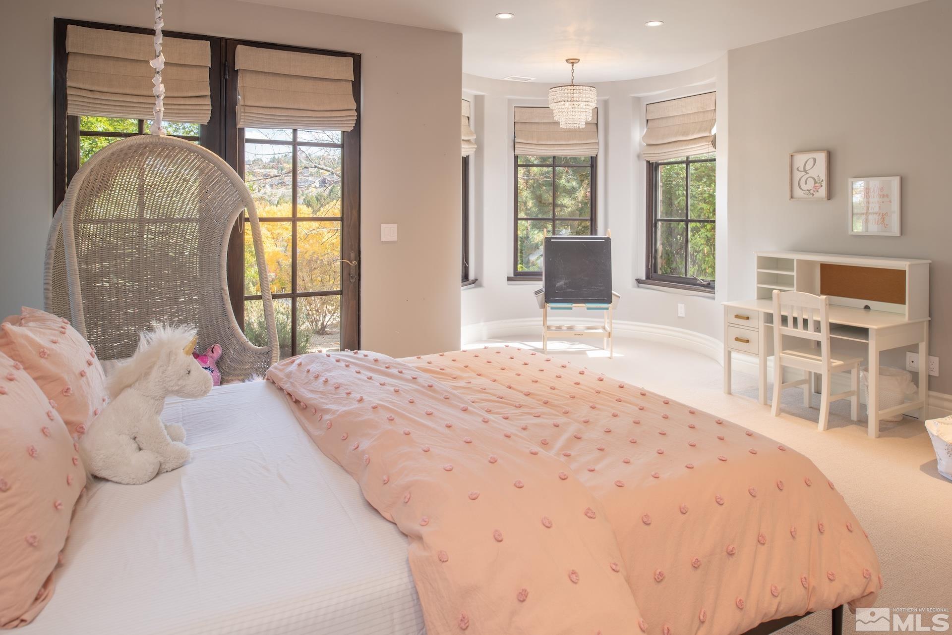 175 Hawken Road Reno, NV 89519 - Photo 36 of 40 a bedroom with a large bed and a chandelier