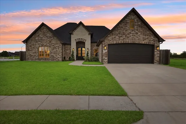 a front view of a house with yard and garage