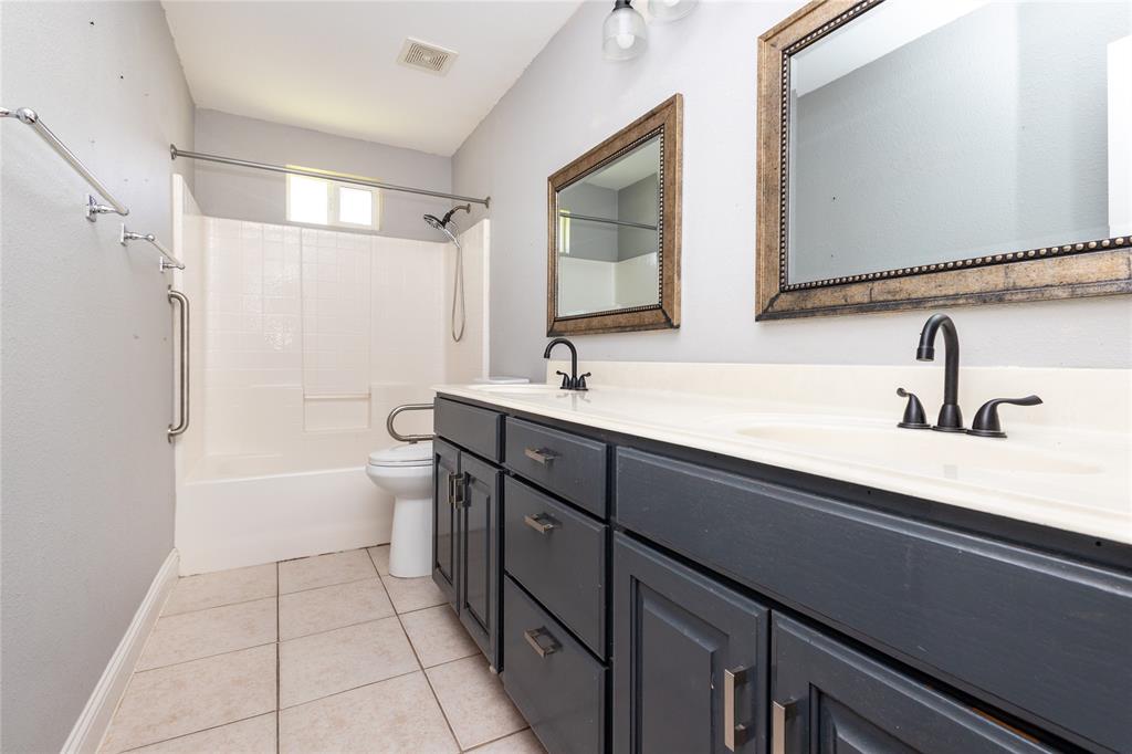 512 Milton Road Josephine, TX 75173 - Photo 12 of 31 a bathroom with a double vanity sink a toilet and a mirror