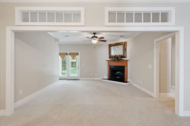 a view of an empty room with a fireplace and chandelier