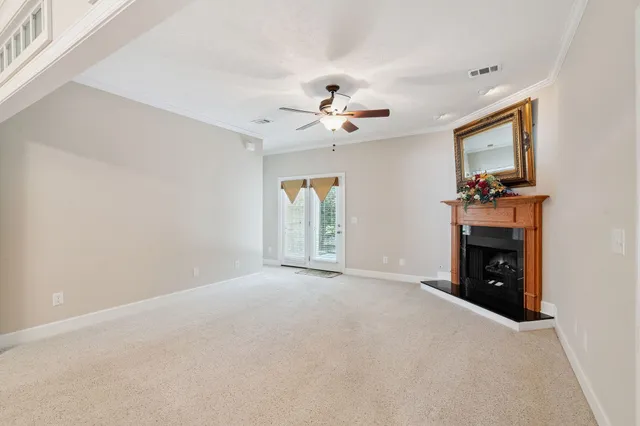 a view of a livingroom with a fireplace and a chandelier fan