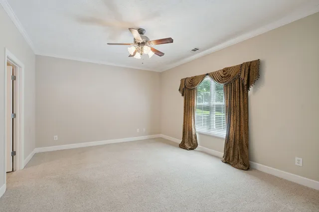 a view of an empty room with a ceiling fan
