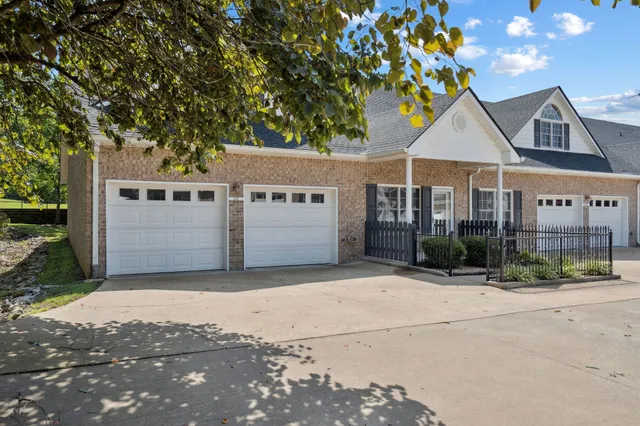 a view of a white house with a large tree