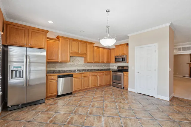 a kitchen with stainless steel appliances granite countertop a refrigerator a sink and a stove