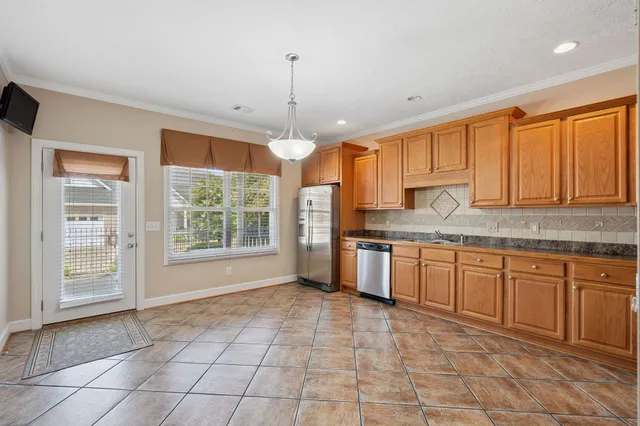 a kitchen with stainless steel appliances granite countertop a stove a sink and a refrigerator