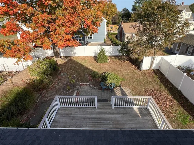 a view of a wooden deck and a backyard