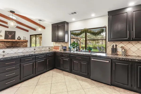 a bathroom with a granite countertop sink a mirror and vanity