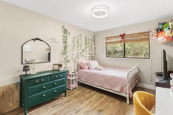 a bedroom with a bed and a painting on the wall