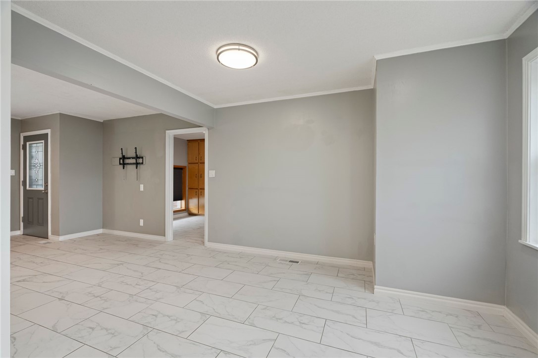 624 Locke Street Alma, AR 72921 - Photo 10 of 32 Spacious room featuring light gray walls, white trim, and white marble-look tile flooring