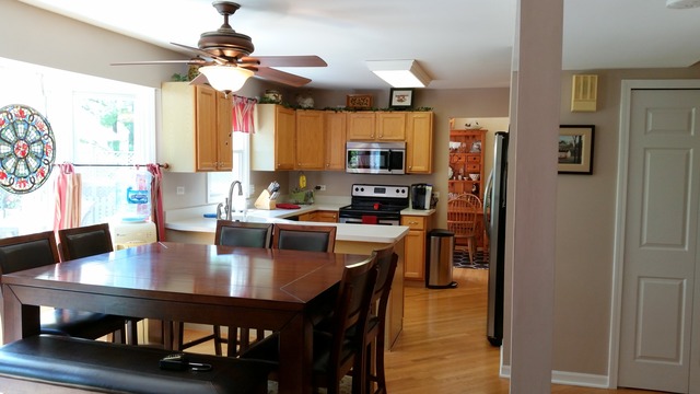 718 Old Hunt Road Fox River Grove, IL 60021 - Photo 8 of 25 a kitchen with a dining table chairs and refrigerator