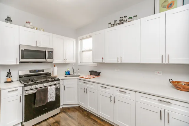 a kitchen with white cabinets and white appliances