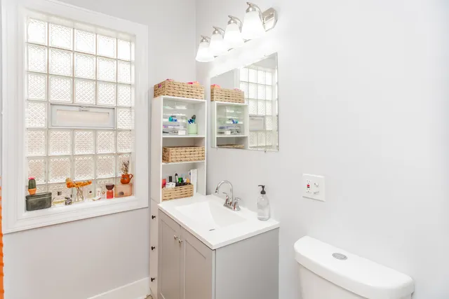 a bathroom with a sink a toilet and a window