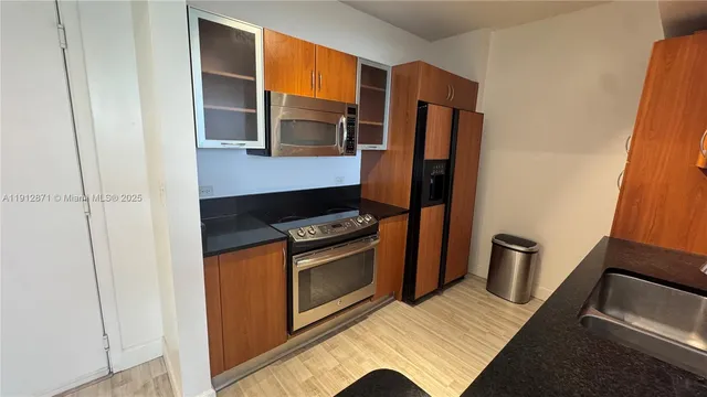 a kitchen with stainless steel appliances granite countertop a refrigerator and a stove top oven