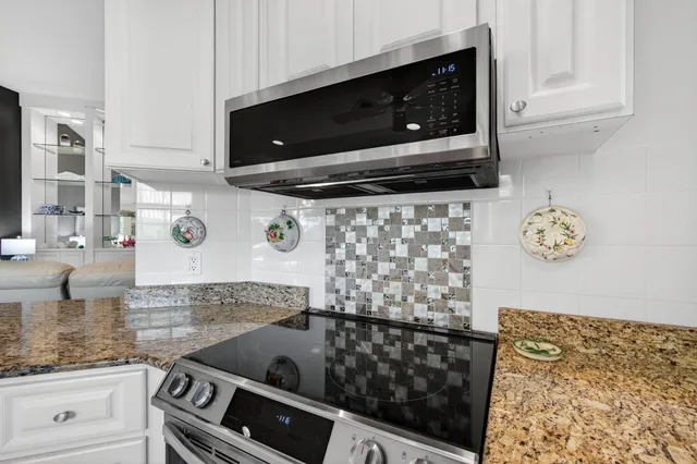 a kitchen with stainless steel appliances granite countertop a stove oven and a sink with granite countertops