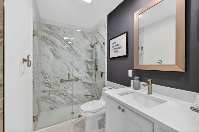 a bathroom with a double vanity sink toilet mirror and shower