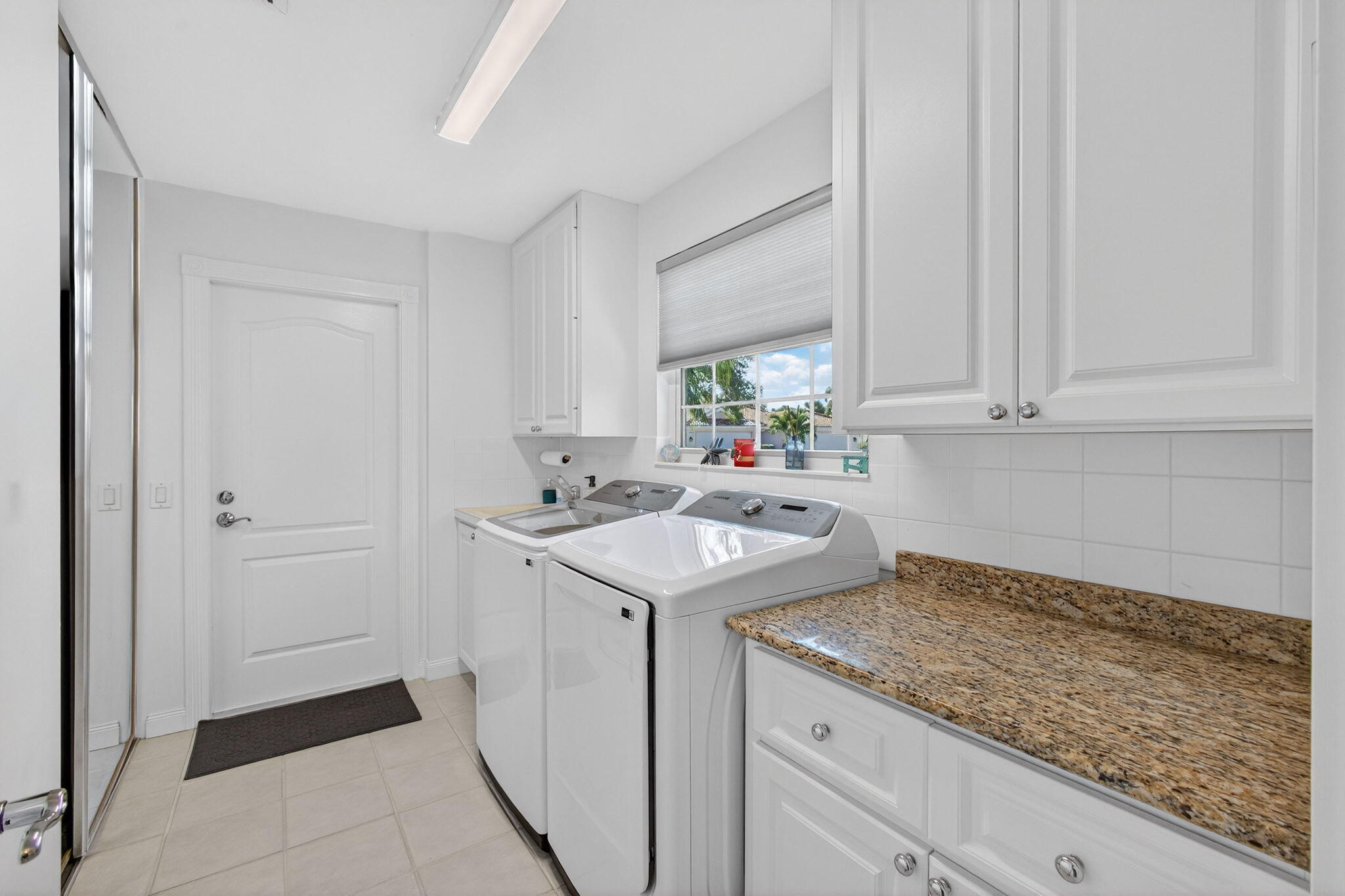 1035 Southwest Tamarrow Place Stuart, FL 34997 - Photo 25 of 42 a utility room with cabinets washer and dryer
