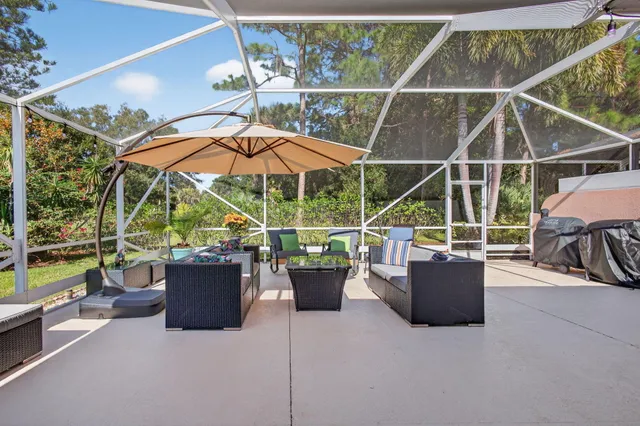 a view of a patio with a dining table and chairs under an umbrella