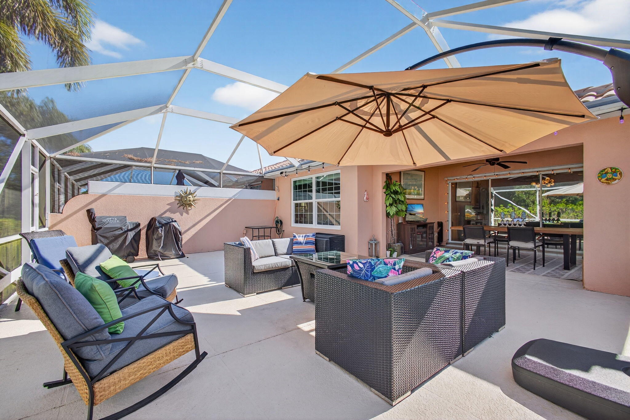 1035 Southwest Tamarrow Place Stuart, FL 34997 - Photo 28 of 42 a view of a patio with a dining table and chairs under an umbrella