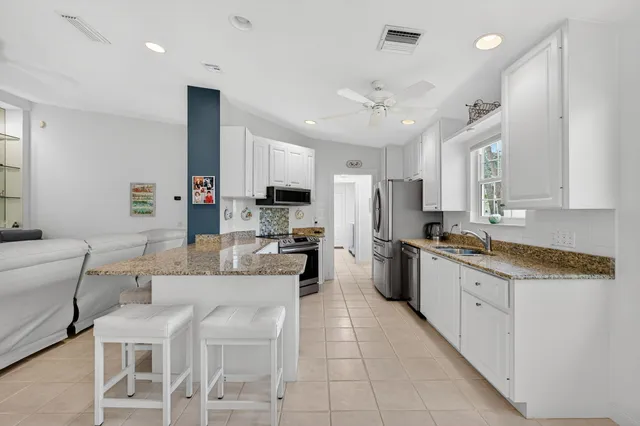 a kitchen with stainless steel appliances kitchen island granite countertop a sink and cabinets
