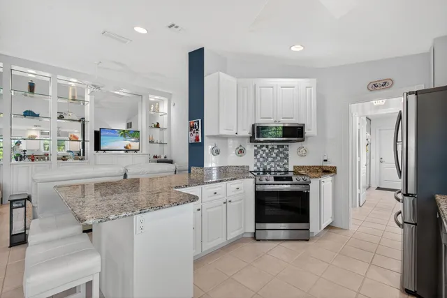 a kitchen with stainless steel appliances granite countertop a stove oven and a refrigerator