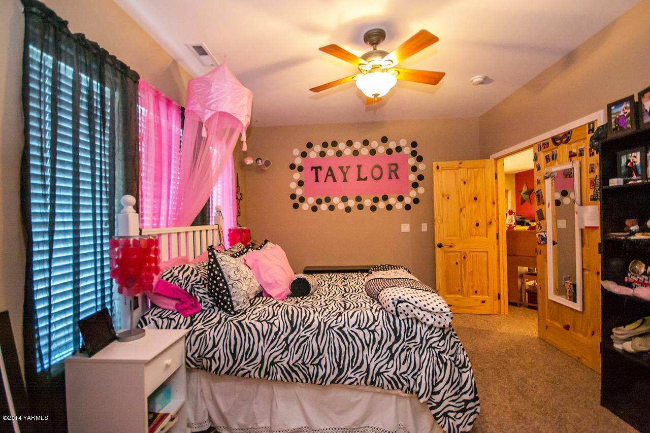 1292 Deeringhoff Road Moxee, WA 98936 - Photo 32 of 42 a bedroom with a bed and a chandelier