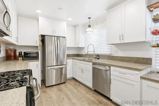 a kitchen with white cabinets and stainless steel appliances