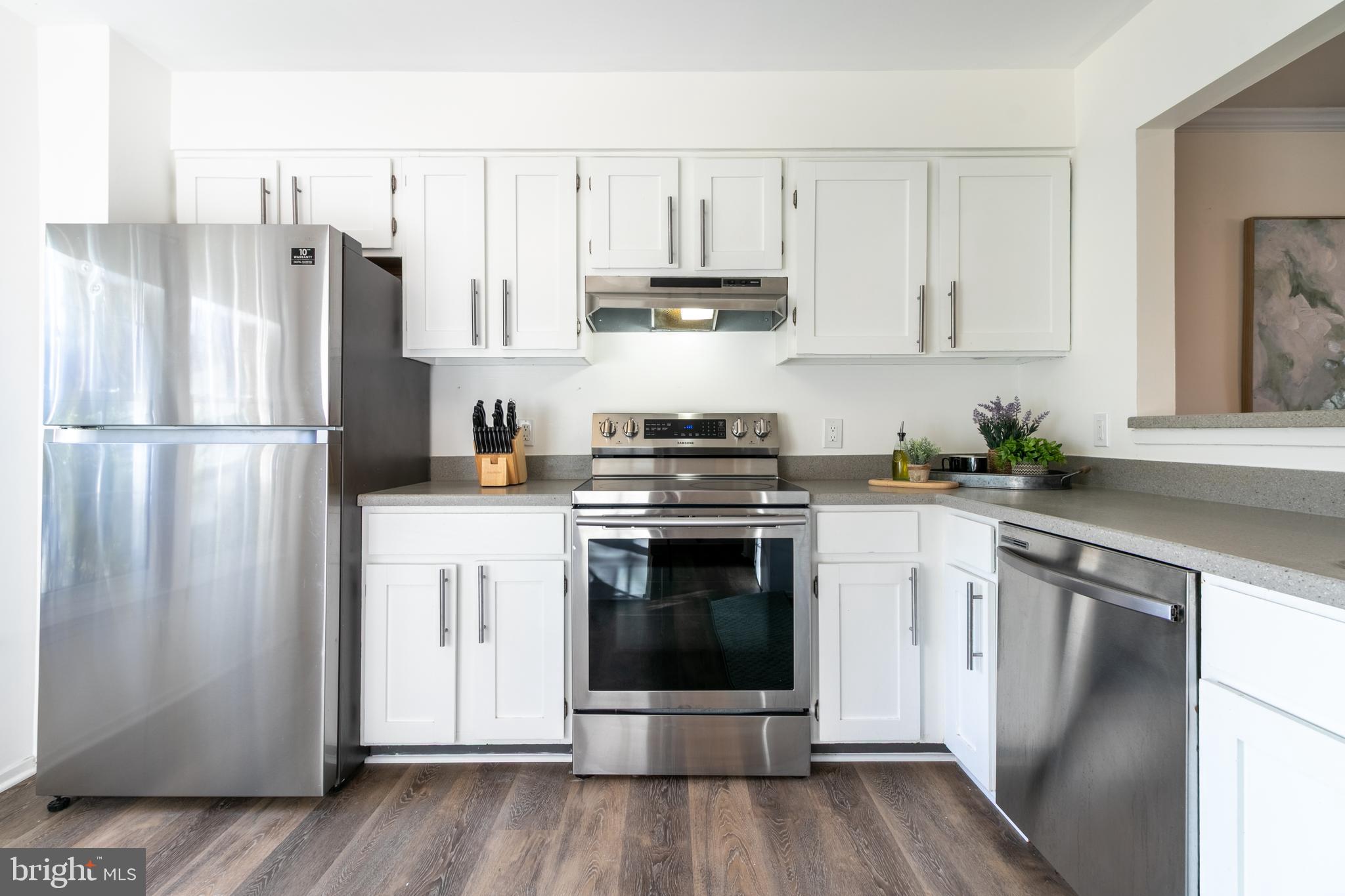 17411 Pipers Way, Unit 7 Olney, MD 20832 - Photo 12 of 22 a kitchen with a refrigerator stove and white cabinets