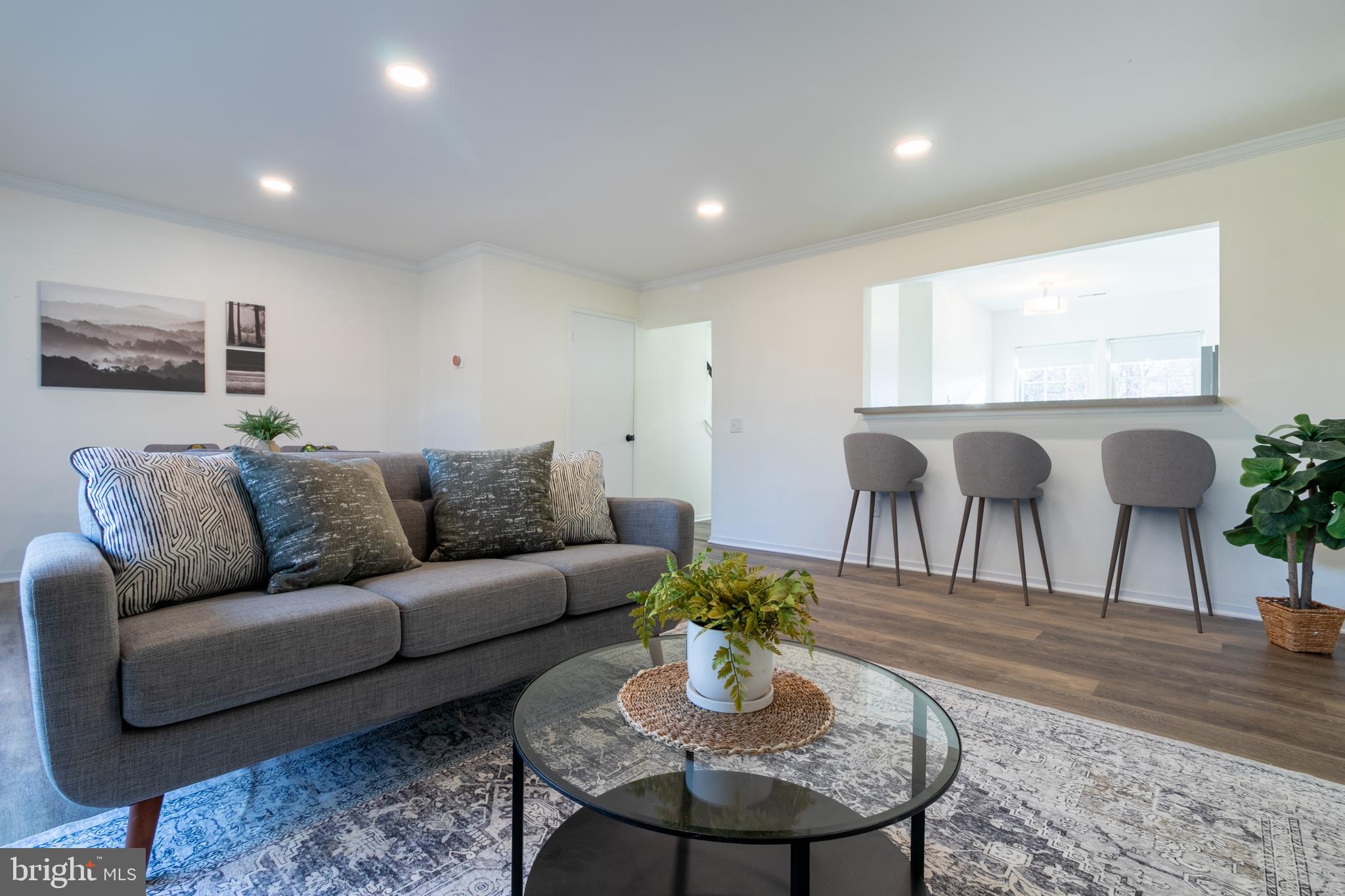 17411 Pipers Way, Unit 7 Olney, MD 20832 - Photo 6 of 22 a living room with furniture a wooden floor and a large window