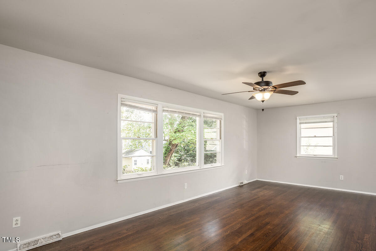 4912 Auburn Road Raleigh, NC 27609 - Photo 10 of 23 a view of an empty room with wooden floor and a window