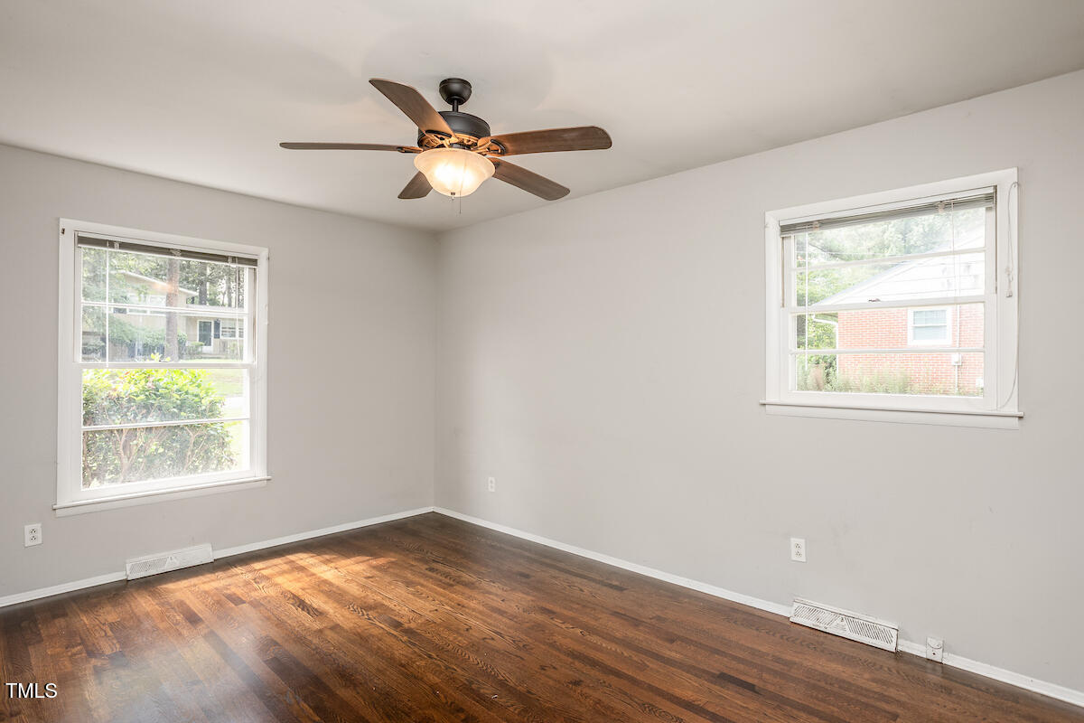 4912 Auburn Road Raleigh, NC 27609 - Photo 12 of 23 a view of an empty room with wooden floor and a window