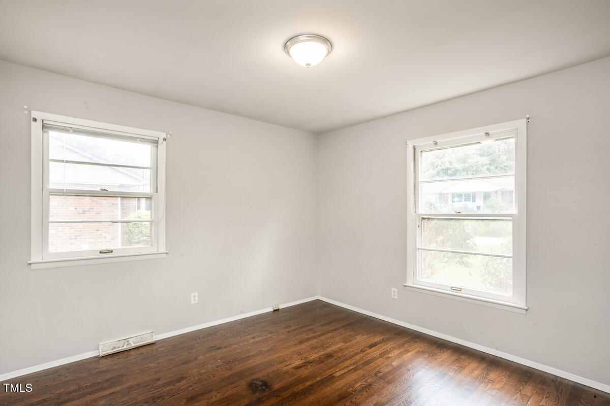 4912 Auburn Road Raleigh, NC 27609 - Photo 15 of 23 an empty room with wooden floor and windows