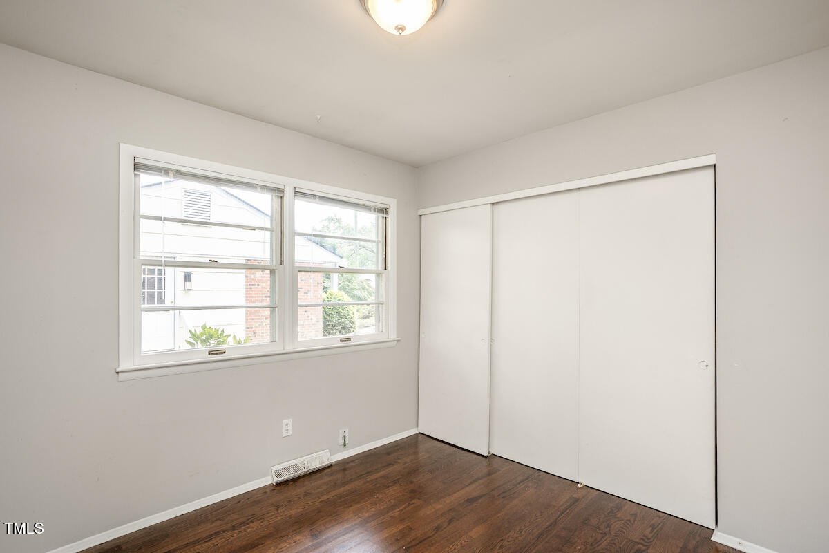 4912 Auburn Road Raleigh, NC 27609 - Photo 16 of 23 an empty room with wooden floor and windows