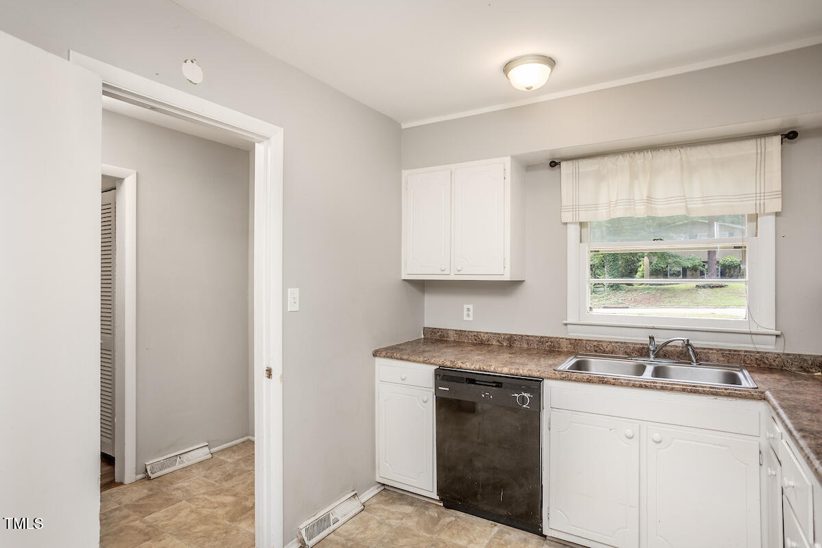 4912 Auburn Road Raleigh, NC 27609 - Photo 3 of 23 a kitchen with a sink stove and cabinets