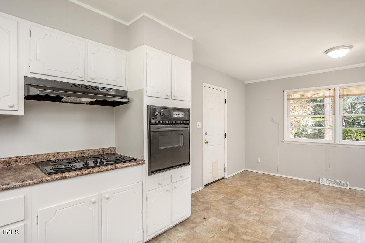 4912 Auburn Road Raleigh, NC 27609 - Photo 5 of 23 a kitchen with a stove and white cabinets