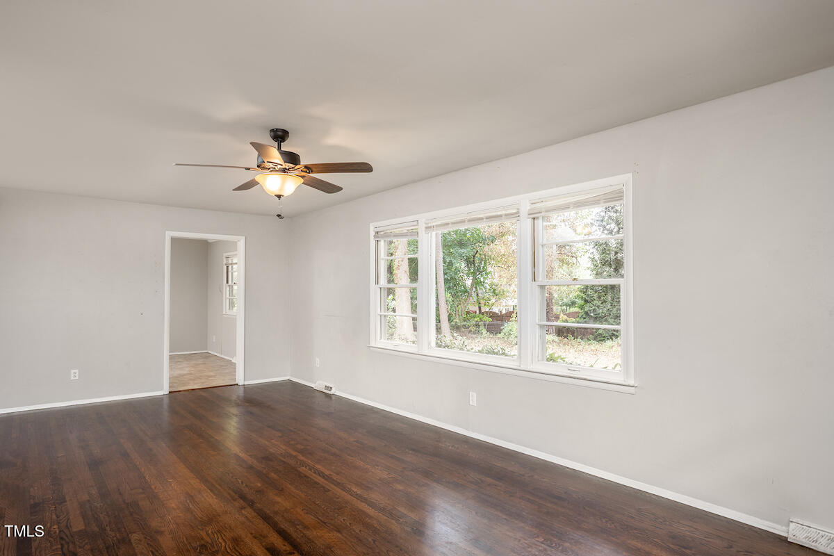 4912 Auburn Road Raleigh, NC 27609 - Photo 8 of 23 a view of an empty room with wooden floor and a window