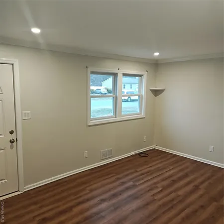 a view of a room with wooden floor and windows