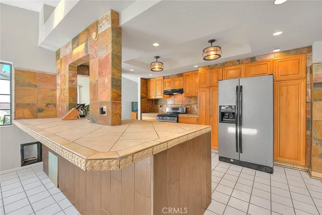 a kitchen with stainless steel appliances kitchen island granite countertop a sink and cabinets