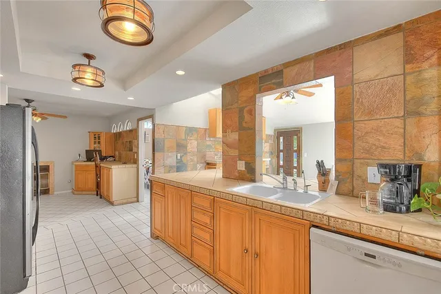 a large kitchen with stainless steel appliances wooden floor and a large window
