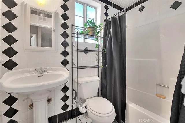 a bedroom with a bed and a lamp on dresser