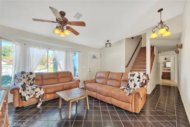 a living room with furniture a dining table and a chandelier