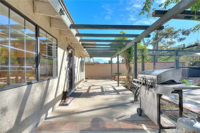 a view of an empty room with window and chandelier fan