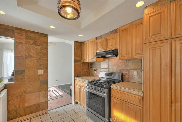 a kitchen with stainless steel appliances granite countertop a stove a refrigerator and a stove