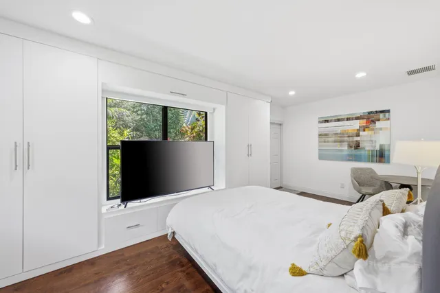 an aerial view of residential houses with outdoor space and trees