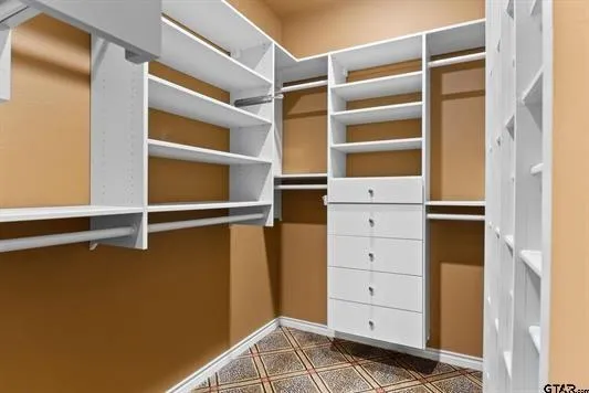 a view of walk in closet with empty racks