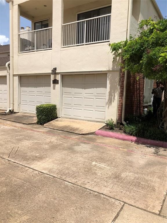 2438 Bering Drive, Unit 2438 Houston, TX 77057 - Photo 3 of 19 a front view of a house with a yard and garage