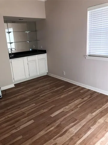 a view of a hallway with wooden floor and a cabinet