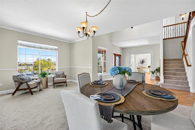 a living room with furniture a dining table and chairs with wooden floor